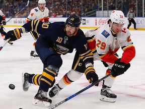 Dillon Dube of the Calgary Flames knocks the puck away from Patrik Berglund of the Buffalo Sabres at the KeyBank Center on October 30, 2018 in Buffalo. (Kevin Hoffman/Getty Images)