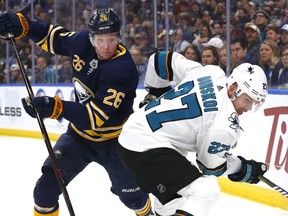 In this Nov. 27, 2018 file photo, Buffalo Sabres defenceman Rasmus Dahlin and San Jose Sharks forward Joonas Donskoi battle in the corner during the first period of an NHL game in Buffalo, N.Y.