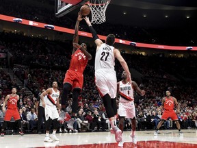 Toronto Raptors forward Serge Ibaka, left, drives to the basket Portland Trail Blazers centre Jusuf Nurkic, right, during the first half of an NBA basketball game in Portland, Ore., Friday, Dec. 14, 2018.