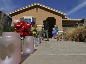 Neighbours write down messages for the Turpin's children on the front door of the home of David and Louise Turpin where police arrested the couple accused of holding 13 children captive in Perris, Calif., Wednesday, Jan. 24, 2018. The Turpin's accused of abusing their 13 children, ranging from 2 to 29, before they were rescued on Jan. 14 from their home in Perris. (AP Photo/Damian Dovarganes)