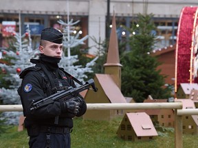 An armed policeman stands guard at Strasbourg's Christmas market, on its reopening day, one day after French police shot dead the gunman who killed three people there. (PATRICK HERTZOG/AFP/Getty Images)