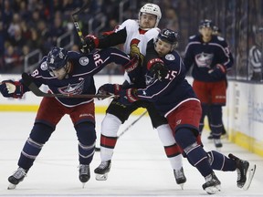 Senators centre Chris Tierney tries to skate between Blue Jackets players Boone Jenner, left, and Markus Nutivaara during the first period of Monday's game.