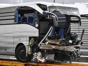 A bus sits on a transport truck after an accident at the highway A3 near Zuerich, Switzerland, on Sunday, Dec. 16, 2018. According to police, one woman died in the accident, 44 people were injured.
