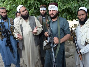 In this file photo taken on June 16, 2018, Afghan Taliban militants stand with a resident as they celebrate the ceasefire on the second day of Eid in the outskirts of Jalalabad. (Getty Images)