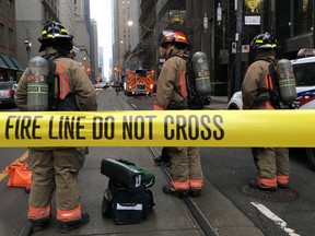 Firefighters stand by their equipment after a bomb threat evacuated the King Street subway station in downtown Toronto on Thursday (Graeme Roy/The Canadian Press)