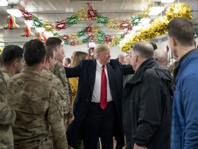 U.S. President Donald Trump visits with members of the military at a dining hall at Al Asad Air Base, Iraq, Wednesday, Dec. 26, 2018.