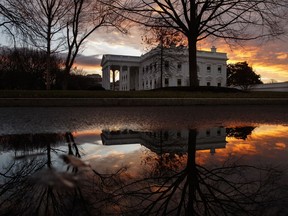 The sun rises behind the White House in Washington, Saturday, Dec. 22, 2018.