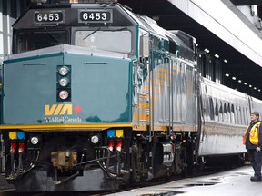 A VIA Rail employee stands on the platform next to a F40 locomotive at the train station in Ottawa on December 3, 2012.