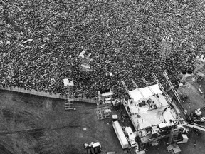 FILE - In this Aug. 16, 1969 file aerial photo, music fans pack around the stage at the original Woodstock Music and Arts Festival, lower right, in Bethel, N.Y. The Bethel Woods Center for the Arts, a concert venue built on the original Woodstock site, announced Thursday, Dec. 27, 2018, that it will host the 50th anniversary of the historic event at the original Woodstock concert site on Aug. 16-18, 2019.