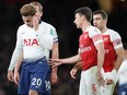 Tottenham's Dele Alli, left, reacts after a bottle was thrown at him from the stands during the English League Cup quarter final soccer match between Arsenal and Tottenham Hotspur at the Emirates stadium in London, Wednesday, Dec. 19, 2018.