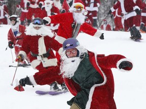 Skiers and snowboarders dressed as Santa Claus hit the slopes en masse during the annual Santa Sunday event, Sunday, Dec. 2, 2018, in Newry, Maine.