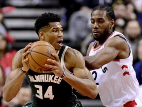 Toronto Raptors forward Kawhi Leonard puts pressure on Milwaukee Bucks forward Giannis Antetokounmpo as he looks for the pass during second half in Toronto on Sunday.