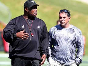 Calgary Stampeders defensive line coach DeVone Claybrooks speaks with former B.C. Lions head coach Mike Benevides on June 9, 2015