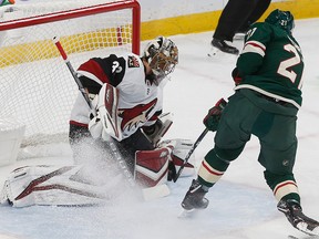 Arizona Coyotes goalie Antti Raanta, left, of Finland, stops a shot by Minnesota Wild's Eric Fehr during the first period of an NHL hockey game Tuesday, Nov. 27, 2018, in St. Paul, Minn.