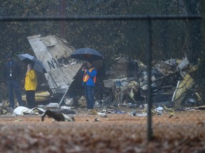 Investigators work the scene of a small plane crash in a city park which killed all on board, Thursday, Dec. 20, 2018, in northwest Atlanta.
