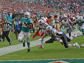 Miami Dolphins running back Kenyan Drake runs for a touchdown during the second half of an NFL football game against the New England Patriots, Sunday, Dec. 9, 2018, in Miami Gardens, Fla.