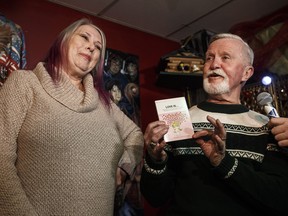 Adrian Pearce and his ex high school girl friend Vicki Allen open the 47 year old gift, a book called Love Is, which she gave him when they broke up in 1971, in St. Albert, Alta., on Thursday, Dec. 6, 2018. 47 years ago Adrian Pearce was given the gift the same day Vicki Allen broke up with him and he never opened it until now. THE CANADIAN PRESS/Jason Franson