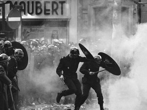 FILE - Anti-riot police charge through the streets of Paris during violent student demonstrations on May. 6, 1968. There are parallels for unpopular French President Emmanuel Macron in the demise of King Louis XVI more than two centuries ago. Democracy has replaced monarchy but the culture of a mob taking its anger against perceived inequality onto the streets of Paris has not changed. (AP Photo/File)
