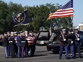The flag-draped casket of former President George H.W. Bush is carried by a joint services military honor guard to Special Air Mission 41 at Ellington Field during a departure ceremony Monday, Dec. 3, 2018, in Houston.