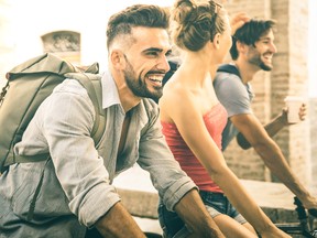 Happy multicultural friends having fun riding bicycle in city old town - Friendship concept with young people students biking together to university college campus - Bright vintage retro filter