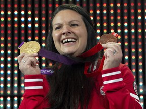 Canadian weightlifter Christine Girard holds up the gold and bronze Olympic medals she was awarded during a ceremony Monday December 3, 2018 in Ottawa. (THE CANADIAN PRESS/Adrian Wyld)