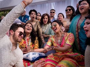 In this Friday, Nov. 30, 2018 handout photo released by Raindrop Media, Bollywood actress Priyanka Chopra and Nick Jonas celebrate during a mehendi ceremony, a day before their wedding, at Umaid Bhawan in Jodhpur, India.