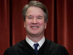 In this Nov. 30, 2018, file photo Associate Justice Brett Kavanaugh sits with fellow Supreme Court justices for a group portrait at the Supreme Court Building in Washington.