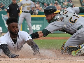 In this June 26, 2018, file photo, Detroit Tigers shortstop Niko Goodrum beats the tag of Oakland Athletics catcher Jonathan Lucroy during the first inning of a baseball game in Detroit.