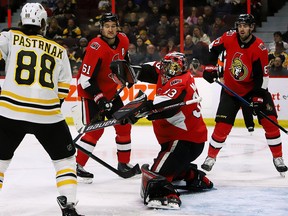 Boston Bruins right wing David Pastrnaklooks on as Ottawa Senators goaltender Mike McKenna  makes a blocker save during first period NHL hockey action in Ottawa on Sunday, Dec. 9, 2018.