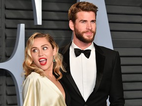 Miley Cyrus (L) and Liam Hemsworth attend the 2018 Vanity Fair Oscar Party hosted by Radhika Jones at Wallis Annenberg Center for the Performing Arts on March 4, 2018 in Beverly Hills, Calif.