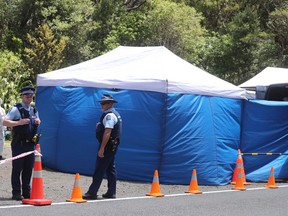 Police investigating the murder of British tourist Grace Millane stand by a cordoned off crime scene along a section of Scenic Drive in the Waitakere Ranges outside Auckland, New Zealand, Sunday, Dec. 9, 2018. New Zealand police said Saturday, Dec. 8, that they believe the 22-year-old British tourist who has been missing for a week was murdered, and they will lay charges against a man they detained earlier in the day for questioning.