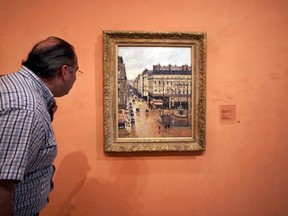 This May 12, 2005, file photo shows an unidentified visitor viewing the Impressionist painting called "Rue St.-Honore, Apres-Midi, Effet de Pluie" painted in 1897 by Camille Pissarro, on display in the Thyssen-Bornemisza Museum in Madrid.