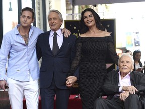 FILE - In this Nov. 6, 2018, file photo, Honoree and actor Michael Douglas, second left, poses with his father actor Kirk Douglas, from right, wife Catherine Zeta-Jones and son Cameron Douglas following a ceremony honoring him with a star on the Hollywood Walk of Fame in Los Angeles. Kirk Douglas celebrated his 102nd birthday with a special video message from his daughter-in-law. Catherine Zeta-Jones posted the video on Instagram Sunday, Dec. 9.