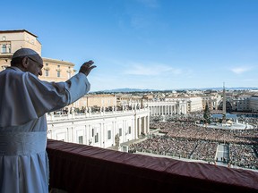 This handout picture released by the Vatican press office on December 25, 2018 at St Peter's square in Vatican shows Pope Francis waving from the balcony of St Peter's basilica during the traditional "Urbi et Orbi" Christmas message to the city and the world.
