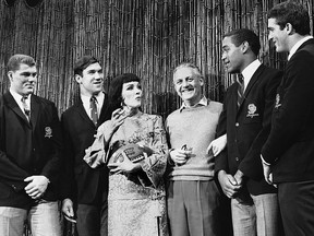 In this Dec. 13, 1967, file photo, Southern California football players Ron Yary, left, Tim Rossovich, second from left, O.J. Simpson, second from right, and Adrian Young, right, visit the set of the movie "Star" at 20th Century-Fox Studios in Hollywood in Los Angeles, Calif., and get a football autographed by movie star Julie Andrews, third from left, as director Robert Wise, third from right, who directs the movie, looks on.