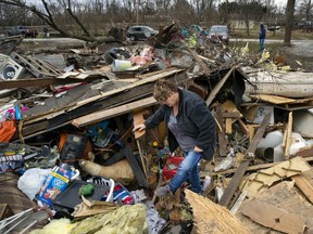 Joyce Morrissey sorts through the debris of her nephew Stephen Tirpak's house in Taylorville, Ill., Sunday, Dec. 2, 2018.