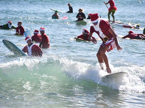 On Christmas Eve in 2009, George Trosset went surfing behind his house in Cocoa Beach, Fla., in a Santa suit with his son and daughter-in-law. A photo made the local paper and next year some friends joined him in Santa suits of their own. Every year, the event got bigger. This year thousands showed up in downtown Cocoa Beach for the annual Christmas Eve Surfing Santas event with hundreds of surfing Santas taking to the waves. The event now raises money for the Florida Surf Museum and Grind for Life. The weather was perfect Florida weather Monday morning with temperatures in the high 60's, unfortunately there were very small waves for the event.