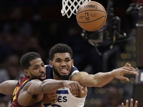 Cleveland Cavaliers' Tristan Thompson, left, and Minnesota Timberwolves' Karl-Anthony Towns battle for a loose ball in the second half of an NBA basketball game, Monday, Nov. 26, 2018, in Cleveland. The Timberwolves won 102-95.