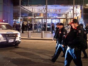 After the building was determined safe, New York City police officers walk from the area of Time Warner Center in New York Thursday, Dec. 6, 2018, after a bomb threat was called into the building and occupants were evacuated, including CNN employees.