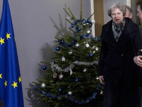 British Prime Minister Theresa May, center, walks past a holiday tree as she leaves the Europa building after a meeting with European Council President Donald Tusk in Brussels, Tuesday, Dec. 11 2018. Top European Union officials on Tuesday ruled out any renegotiation of the divorce agreement with Britain, as Prime Minister Theresa May fought to save her Brexit deal by lobbying leaders in Europe's capitals.
