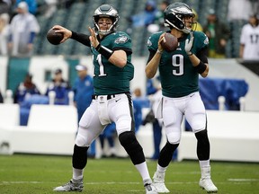 In this Sept. 23, 2018, file photo, Philadelphia Eagles quarterback Carson Wentz and quarterback Nick Foles throw before an NFL game against the Indianapolis Colts, in Philadelphia.