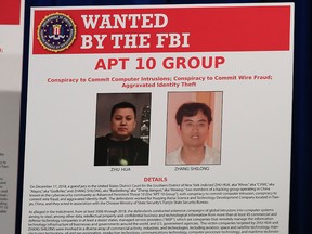 A poster displayed during a news conference at the Department of Justice in Washington, Thursday, Dec. 20, 2018, shows Zhu Hua and Zhang Shillong, two Chinese citizens suspected to be with the group APT 10 carrying out an extensive hacking campaign to steal data from U.S. companies.