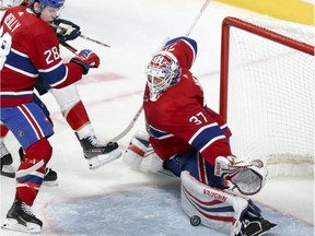 Canadiens Antti Niemi makes a pad save as Mike Reilly boxes out a Panthers players during the third period Tuesday night. It was one of 52 saves the backup made.