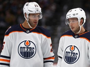Darnell Nurse and Ryan Spooner of the Edmonton Oilers confer while playing the Colorado Avalanche at the Pepsi Center on Dec. 11, 2018 in Denver.