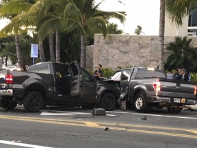 In this photo taken Monday, Jan. 28, 2019, is the scene of a multiple vehicle accident involving two trucks and a bicyclist in Honolulu. (Cindy Ellen Russell/Honolulu Star-Advertiser via AP)