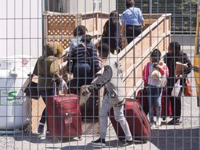 A group of asylum seekers arrive at the temporary housing facilities at the border crossing Wednesday May 9, 2018 in St. Bernard-de-Lacolle, Que