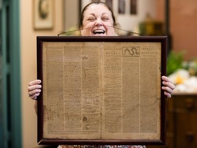 In this Thursday, Oct. 25, 2018 file photo, Heather Randall displays a Dec. 28, 1774 Pennsylvania Journal and the Weekly Advertiser at the Goodwill Industries South Jersey in Bellmawr, N.J.