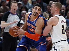 New York Knicks center Enes Kanter, left, is defended by Denver Nuggets forward Mason Plumlee during the second half of an NBA basketball game Tuesday, Jan. 1, 2019, in Denver. (AP Photo/David Zalubowski)