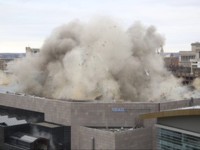 Smoke rises in the air as part of the roof of the Bradley Center is imploded during a controlled demolition in Milwaukee on Sunday, Jan. 13, 2019. (Mike De Sisti/Milwaukee Journal-Sentinel via AP)