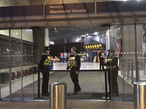 Police at Victoria Station in Manchester, England, late Monday, Dec. 31, 2018 after a man had stabbed three people.